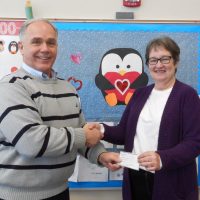Kim Tate of the Shelby Optimist Club presents a $1,000 check to Hesperia Community Library Director Kay Brennan.